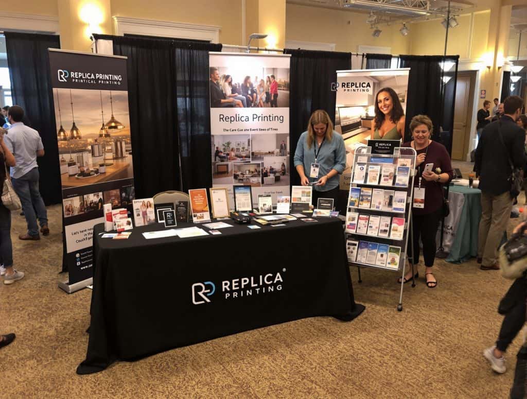 event booth setup at a trade show or summer event, prominently featuring the Replica Printing brand.