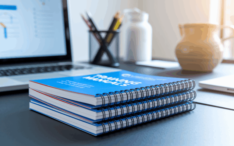 printed training manuals stacked on a desk